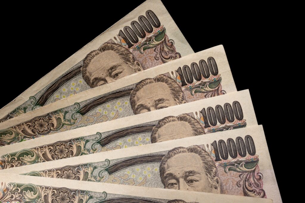 黒いバックグラウンドにある5枚の一万円札